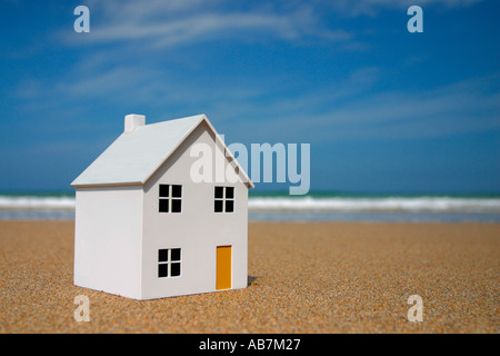 Maison modèle sur la plage avec des vagues de l'océan en arrière-plan Banque D'Images