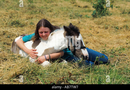 Tinker Cheval (Equus caballus przewalskii. f), girl embracing poulain Banque D'Images