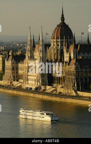 Un bateau qui passe devant le Parlement hongrois qui se trouve Sur la place Lajos Kossuth à Budapest, Hongrie Banque D'Images