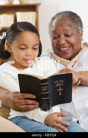 Senior woman lire la Bible à sa petite-fille Banque D'Images