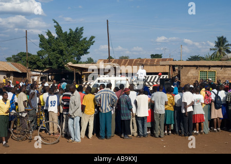 Les spectateurs à regarder un groupe de théâtre d'effectuer une campagne de sensibilisation au VIH/SIDA sur un marché à Moshi Tanzanie Banque D'Images