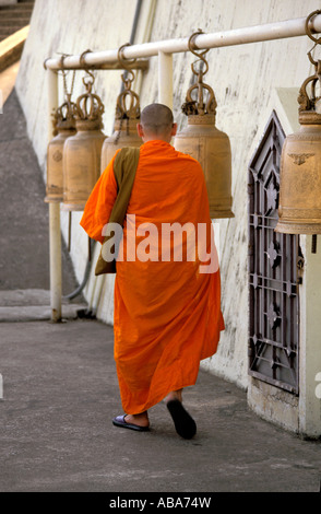 Le moine bouddhiste temple cloches marche passé accroché au poteau horizontal, Wat Saket aka le Mont d'or, Bangkok, Thaïlande Banque D'Images