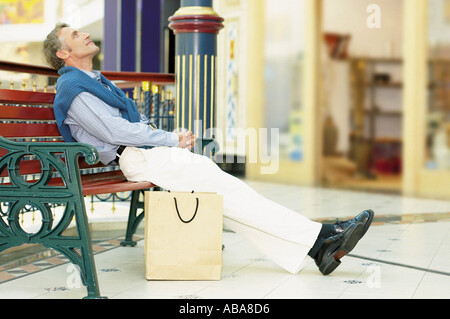 Homme assis sur un banc Banque D'Images