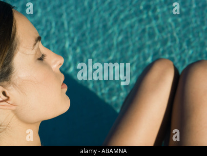 Visage de femme et les jambes vu sur l'eau de piscine, high angle view Banque D'Images