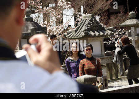 Les touristes japonais à prendre des photos au complexe du Temple Kiyomizudera entouré de cerisiers de Kyoto, Japon Banque D'Images