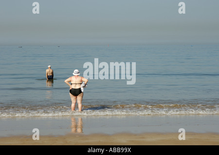 Couple senior sur la plage pagayant dans la mer. Vue arrière. Banque D'Images