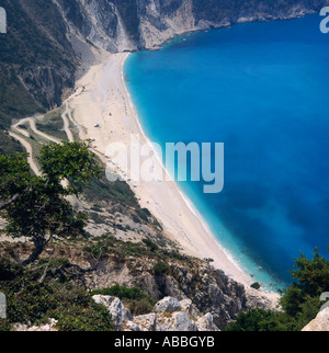 Regardant vers le bas sur la baie avec l'eau bleu clair plage de sable blanc et le bas de la route en zig-zag Mirtos à flanc de l'île de Céphalonie îles Grecques Banque D'Images