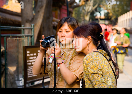 De belles jeunes femmes chinoises affichage de photos sur l'appareil photo numérique dans la Forbidden City Beijing Chine JMH1448 Banque D'Images