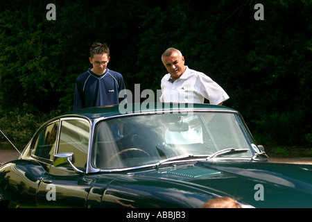 Deux hommes l'étude d'une Jaguar Type E Voiture de sport classique Banque D'Images