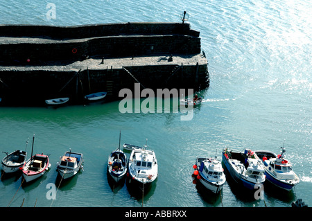 Un pêcheur chugs dans le petit port de pêche pittoresque de Clovelly sur la côte nord du Devon Banque D'Images