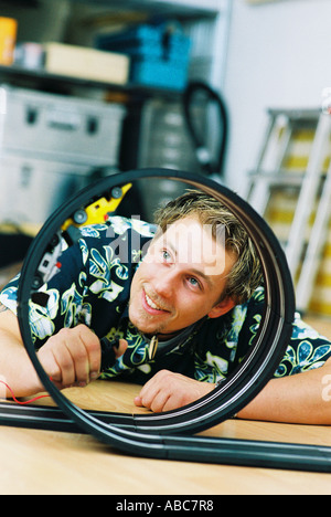 Jeune homme jouant avec petite voiture speedway Banque D'Images