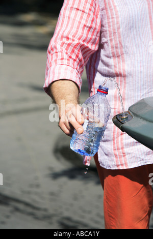 Part de la mise à niveau de l'eau dans une bouteille en plastique lors d'une fontaine d'eau fraîche de printemps à Paris Banque D'Images