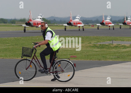 Le personnel de l'aéroport de location en attendant de traverser l'aire de circulation rampe avec taxying avions occupé Banque D'Images