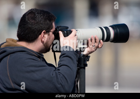 Un photographe nous tend un téléobjectif Canon 100-400G sur un EOS 20D appareil photo. Banque D'Images