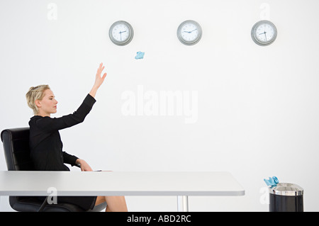 Businesswoman throwing paper dans le bac Banque D'Images