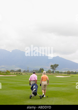 Couple walking on golf course Banque D'Images