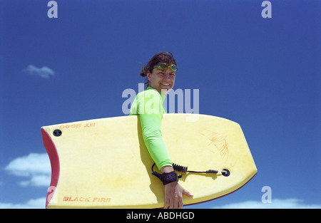 Young woman carrying boogieboard Banque D'Images