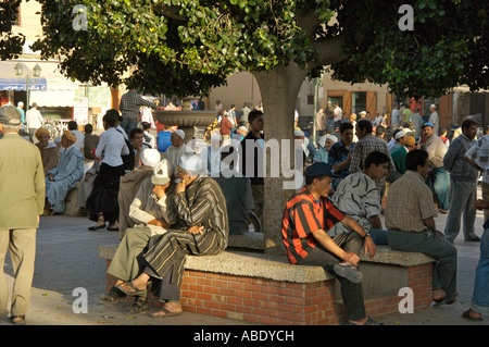 Les hommes se détendre et parler en place place Assarag au coucher du soleil. Taroudant, Maroc Banque D'Images