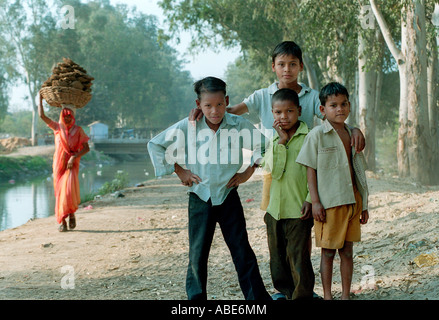 Quatre garçons indiens et femme transportant dung pour combustible Banque D'Images
