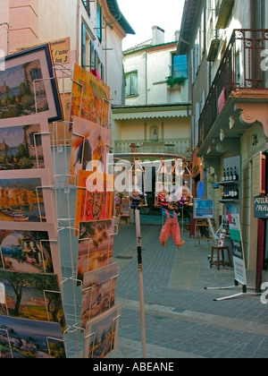 Cartes postales en vente dans une ruelle dans la vieille ville de Collioure avec devantures aux couleurs criardes de maisons Banque D'Images