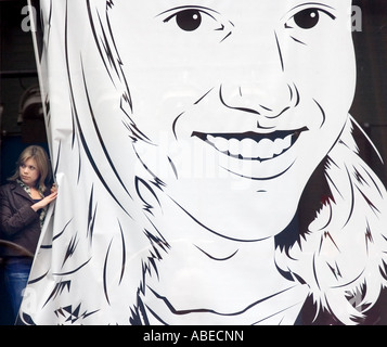 Une femme se profile derrière une grande affiche de raccrocher au MTV studios de radiodiffusion à Times Square, New York, New York. Banque D'Images