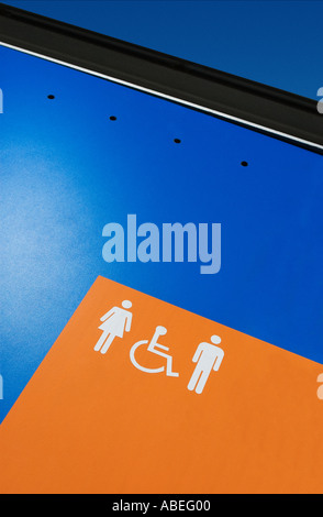 Toilettes WC hommes, femmes et handicapés SIGNE SUR FOND ORANGE Banque D'Images