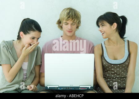 Groupe de jeunes amis using laptop Banque D'Images