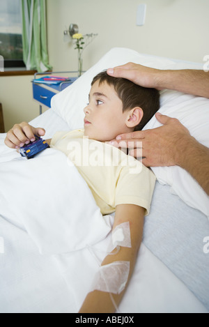 Boy lying in hospital bed ayant pris d'impulsions Banque D'Images