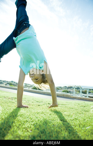 Girl doing cartwheel on grass Banque D'Images