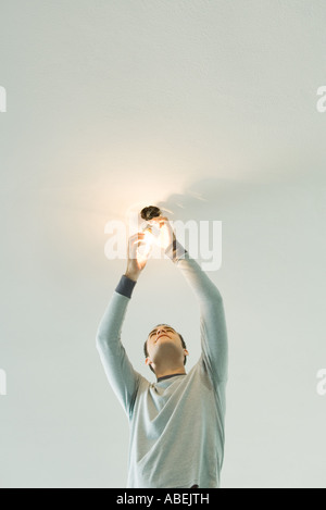 Man changing lightbulb Banque D'Images