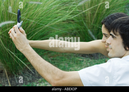 Jeune couple taking photo de pagax with cell phone Banque D'Images