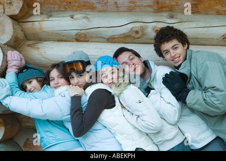 Young Friends standing par log cabin, appuyée sur l'autre, portrait Banque D'Images