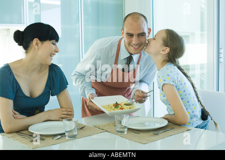 L'homme au service de l'épouse et la fille de spaghetti, girl kissing father on cheek Banque D'Images