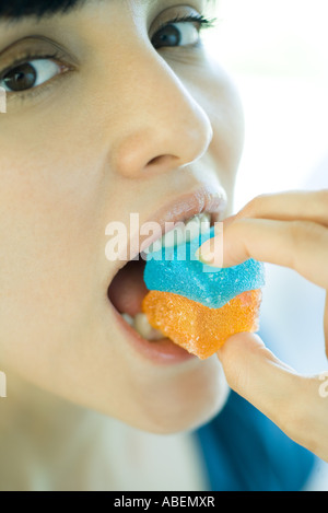 Woman biting en bonbons, close-up Banque D'Images