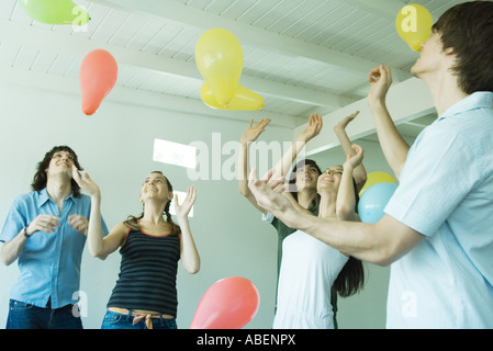Groupe de jeunes amis de frapper des ballons flottent dans l'air Banque D'Images