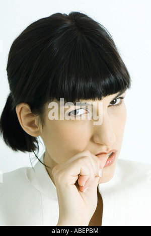 Woman biting thumb, portrait Banque D'Images