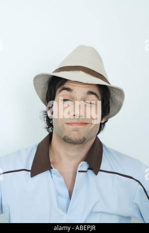 Young man wearing hat, clignant de l'at camera, portrait Banque D'Images