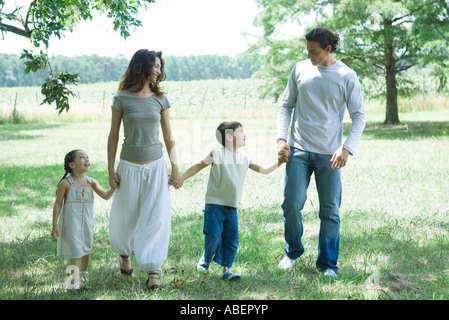 Balades Familiales à travers l'herbe, se tenant la main, front view Banque D'Images