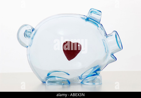 Forme de coeur suspendu dans piggy bank Banque D'Images