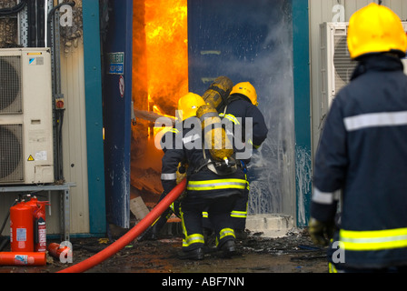 Les pompiers feu entrant dans un immeuble par une porte coupe-feu. Une branche et BA UK Banque D'Images