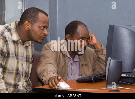 Les hommes l'étude de l'écran d'ordinateur, les télécommunications, l'Autorité éthiopienne Addis Abeba, Ethiopie Banque D'Images