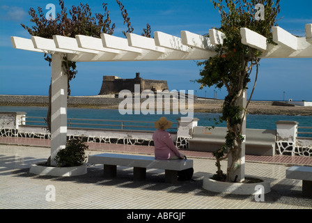 Dh Avenida La Marina Arrecife Lanzarote touriste assis de banquette à la promenade au château de San Gabriel Banque D'Images