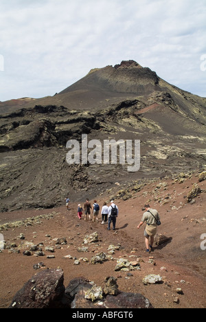 Dh Le Parc National de Timanfaya LANZAROTE TIMANFAYA Visite guidée les randonneurs de trekking à travers les bombes de lave fusiformes sur le côté du volcan Banque D'Images