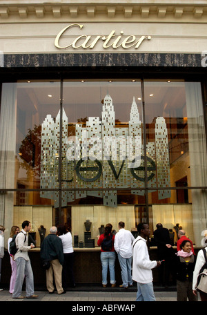 Les touristes regarder les bijoux en vente dans la boutique Cartier sur l'avenue des Champs Elysées Paris France Banque D'Images