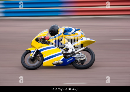 Une course moto jaune flou de vitesse de panoramique Banque D'Images