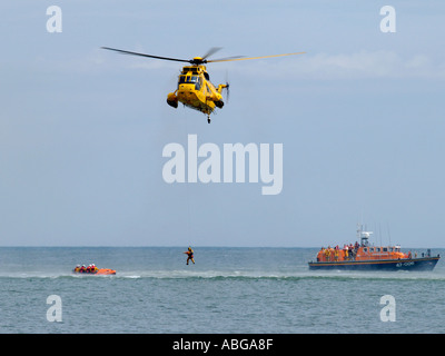 La vie côtière de la RNLI lifeboat bateau en exercice avec raf hélicoptère de sauvetage au large de Norfolk walcott East Anglia angleterre uk Banque D'Images