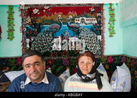 Roma mariés couple dans leur maison simple (tapisserie symbolisant la richesse), Roumanie Banque D'Images