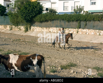 Jeune couple équitation le même cheval à la Romeria, Fuengirola Fuengirola, Costa del Sol, Espagne, Europe, Banque D'Images