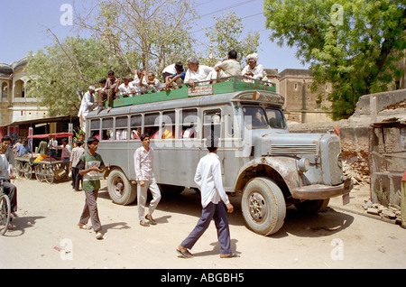 Scène de rue typique dans le Nord de l'Inde montrant bus bondé avec des passagers assis sur le toit Banque D'Images