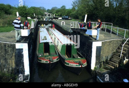 Paire de narrowboats laissant un verrou à Hatton serrures, Grand Union Canal, Warwickshire, England, UK Banque D'Images